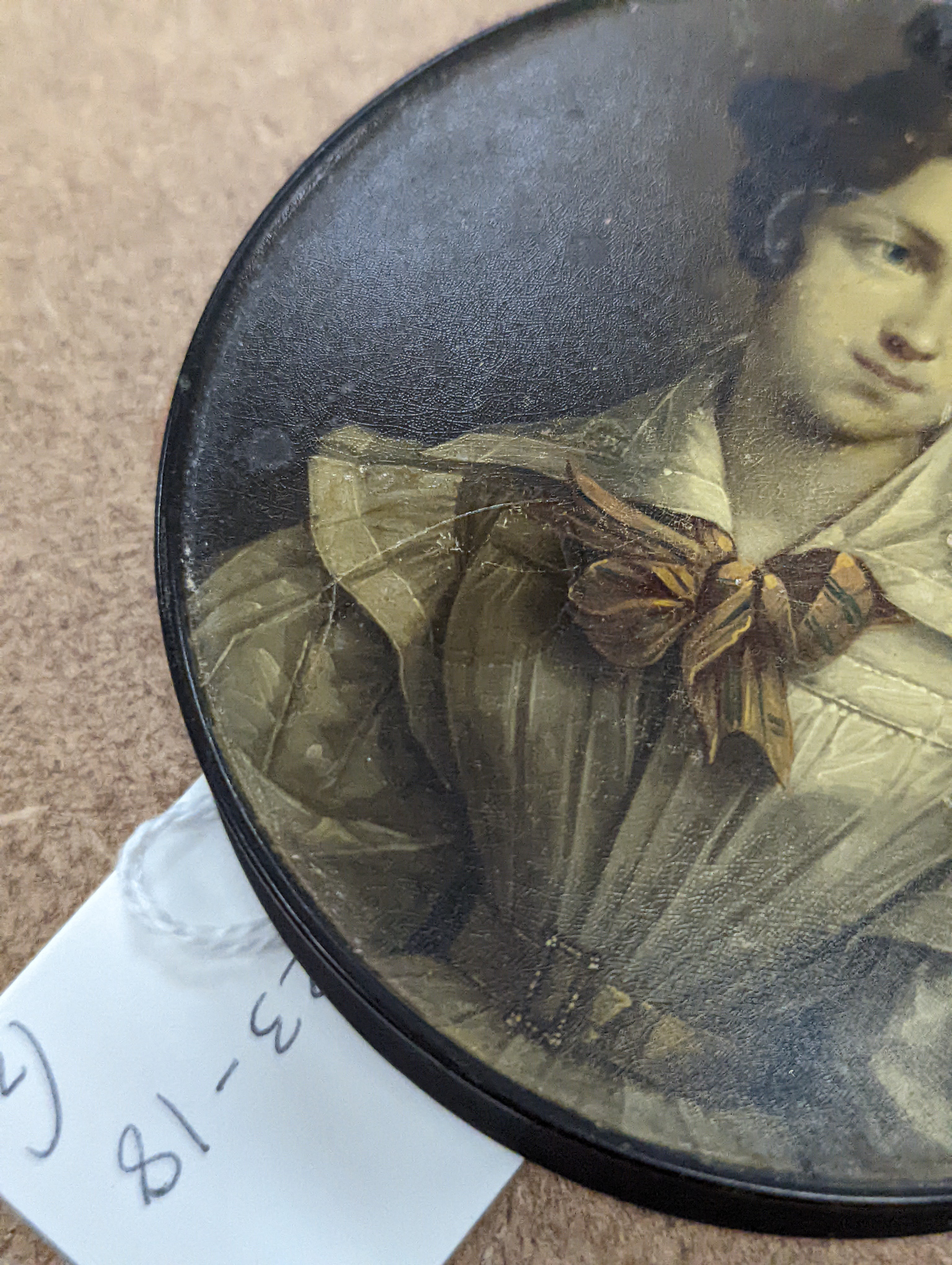 A 19th century Stobwasser papier mache ‘Henriette Sonntag’ portrait snuff box, c.1830, 9.7cm diameter and a 19th-century papier mache snuff box painted with a portrait of a German hussar, 9.4cm (2)